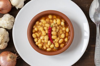 Tahta arka planda sıcak Türk fasulyesi güveci. Kuru Fasulye güvecinde pişirilmiş İsspir fasulyesi. Üst görünüm