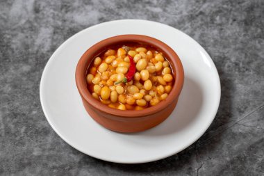 Koyu arkaplanda sıcak Türk fasulye güveci. Kuru Fasulye güvecinde pişirilmiş İsspir fasulyesi.