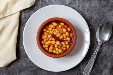 Koyu arkaplanda sıcak Türk fasulye güveci. Kuru Fasulye güvecinde pişirilmiş İsspir fasulyesi. Üst görünüm