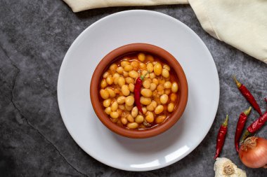 Koyu arkaplanda sıcak Türk fasulye güveci. Kuru Fasulye güvecinde pişirilmiş İsspir fasulyesi. Üst görünüm