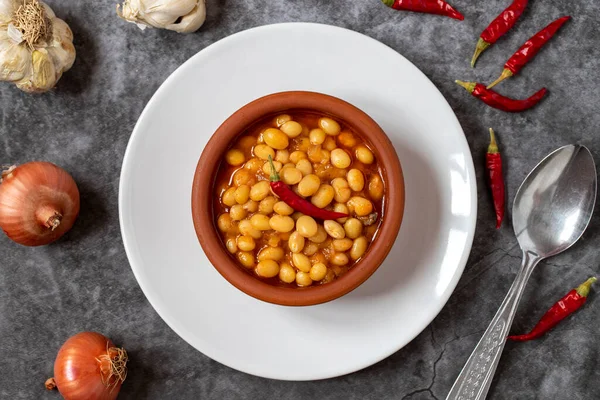 Koyu arkaplanda sıcak Türk fasulye güveci. Kuru Fasulye güvecinde pişirilmiş İsspir fasulyesi. Üst görünüm