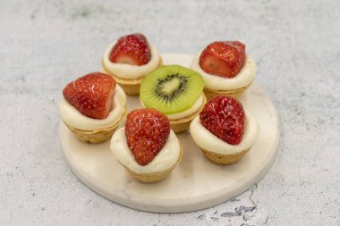 Taş bir arka planda lezzetli minik tartlar (turtalar, açık hamur tatlısı). Kapat.