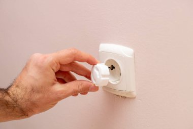 Fiş, elektrik prizinin elektrik şokuna karşı mekanik koruması, çocuklar için güvenli ev. Yatay görüş. Seçici odak