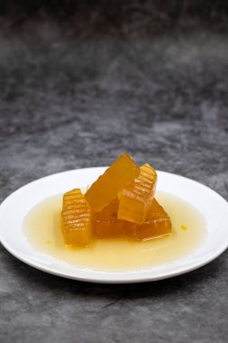 Koyu arkaplanlı balkabağı tatlısı. Geleneksel Akdeniz mutfağı lezzetleri. Türk Ramazan tatlısı. Dikey görünüm. Kapat.