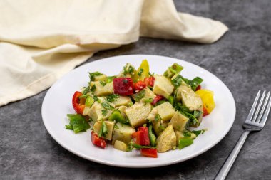 Koyu arkaplanda zeytinyağlı enginar salatası. Geleneksel lezzetli Türk yemekleri; (zeytinyagli motor). Yatay görüş. Kapat.