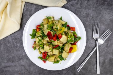 Koyu arkaplanda zeytinyağlı enginar salatası. Geleneksel lezzetli Türk yemekleri; (zeytinyagli motor). Üst Manzara. Kapat.