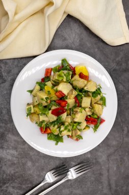 Koyu arkaplanda zeytinyağlı enginar salatası. Geleneksel lezzetli Türk yemekleri; (zeytinyagli motor). Üst Manzara. Kapat.