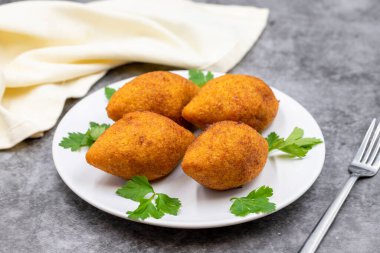 Koyu bir arka planda Kibbeh. Kibbeh, Orta Doğu mutfağında popüler bir yemektir. Doldurulmuş köfteler, falafel, icli Kofta, Quibe. Yatay görüş. Kapat.