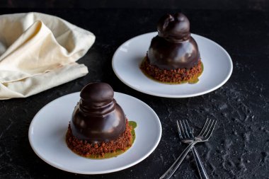 Profiterol keki koyu bir arka planda. Sıvı çikolata ve profiterollü kek. Yakın plan. Yatay görünüm