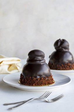 Beyaz arka planda profiterol keki. Sıvı çikolata ve profiterollü kek. Yakın plan. Dikey görünüm