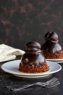 Profiterol keki koyu bir arka planda. Sıvı çikolata ve profiterollü kek. Yakın plan. Dikey görünüm