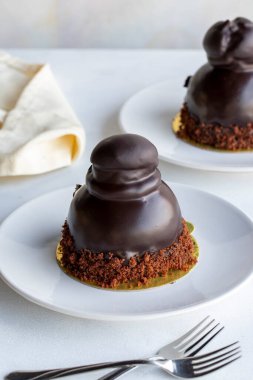 Beyaz arka planda profiterol keki. Sıvı çikolata ve profiterollü kek. Yakın plan. Dikey görünüm