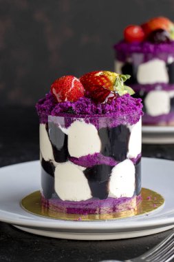 Karanlık bir arka planda orman meyveli mini kek. Yakın plan. Dikey görünüm