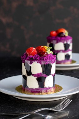 Karanlık bir arka planda orman meyveli mini kek. Yakın plan. Dikey görünüm