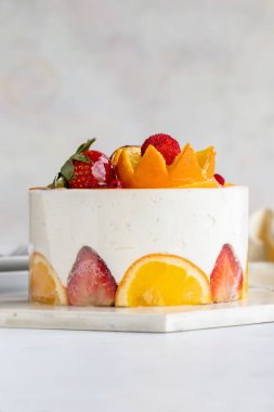 Beyaz arka planda meyveli kek var. Beyaz kremalı meyveli kek. Yakın plan. Dikey görünüm
