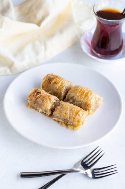 Beyaz tabakta ceviz baklavası. Türk mutfağı aromalı baklava. Dikey görünüm.