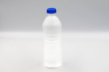 Beyaz arka planda suyla dolu evcil hayvan şişesi. Yakın plan. Yatay görünüm