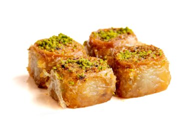 Beyaz arka planda fıstıklı baklava tatlısı. Türk tatlısı konsepti. Bir tabak fıstıklı baklava. Şerbet tatlı Akdeniz fırını. Kapatın. Seçici odaklanma. Dikey görünüm. Hikaye biçimi. Yerel adı fstkl saray sarmas baklava