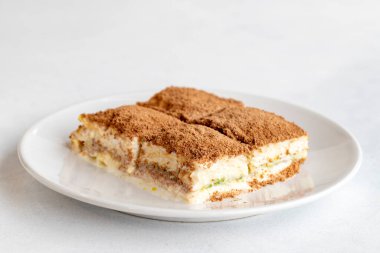 Beyaz arka planda soğuk baklava. Türk tatlısı konsepti. Bir tabak dilimlenmiş orman meyveli kek. Bir tabak soğuk süt baklavası. Akdeniz pastanesi. Kapat. Seçici odaklanma. Yatay görüş. Yerel adı soguk baklava