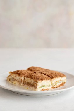 Beyaz arka planda soğuk baklava. Türk tatlısı konsepti. Bir tabak dilimlenmiş orman meyveli kek. Bir tabak soğuk süt baklavası. Akdeniz pastanesi. Kapat. Seçici odaklanma. Dikey görünüm. Hikaye biçimi. Yerel adı soguk baklava