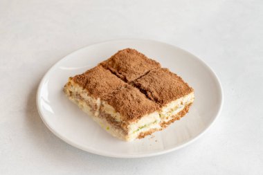 Beyaz arka planda soğuk baklava. Türk tatlısı konsepti. Bir tabak dilimlenmiş orman meyveli kek. Bir tabak soğuk süt baklavası. Akdeniz pastanesi. Kapat. Seçici odaklanma. Yatay görüş. Yerel adı soguk baklava