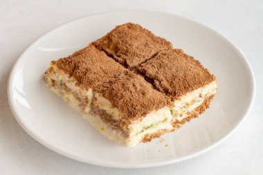 Beyaz arka planda soğuk baklava. Türk tatlısı konsepti. Bir tabak dilimlenmiş orman meyveli kek. Bir tabak soğuk süt baklavası. Akdeniz pastanesi. Kapat. Seçici odaklanma. Yatay görüş. Yerel adı soguk baklava