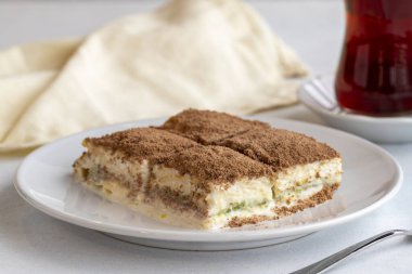 Beyaz arka planda soğuk baklava. Türk tatlısı konsepti. Bir tabak dilimlenmiş orman meyveli kek. Bir tabak soğuk süt baklavası. Akdeniz pastanesi. Kapat. Seçici odaklanma. Yatay görüş. Yerel adı soguk baklava