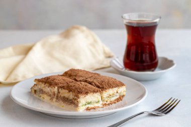 Beyaz arka planda soğuk baklava. Türk tatlısı konsepti. Bir tabak dilimlenmiş orman meyveli kek. Bir tabak soğuk süt baklavası. Akdeniz pastanesi. Kapat. Seçici odaklanma. Yatay görüş. Yerel adı soguk baklava