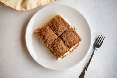Beyaz arka planda soğuk baklava. Türk tatlısı konsepti. Bir tabak dilimlenmiş orman meyveli kek. Bir tabak soğuk süt baklavası. Akdeniz pastanesi. Kapat. Seçici odaklanma. Üst Manzara. Yerel adı soguk baklava