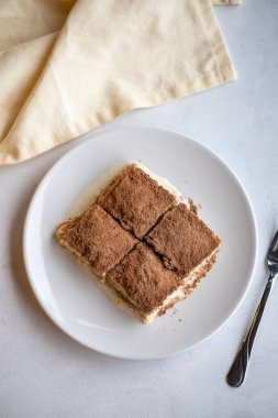 Beyaz arka planda soğuk baklava. Türk tatlısı konsepti. Bir tabak dilimlenmiş orman meyveli kek. Bir tabak soğuk süt baklavası. Akdeniz pastanesi. Kapat. Seçici odaklanma. Dikey görünüm. Hikaye biçimi. Yerel adı soguk baklava