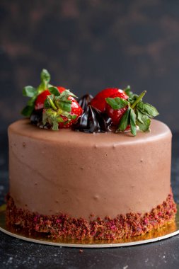 Koyu arkaplanda çilekli ve çikolatalı pasta. Dikey görünüm. Yakın plan kutlama pastası. Hikaye biçimi