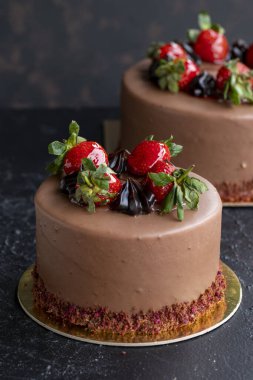 Koyu arkaplanda çilekli ve çikolatalı pasta. Dikey görünüm. Yakın plan kutlama pastası. Hikaye biçimi