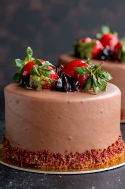 Koyu arkaplanda çilekli ve çikolatalı pasta. Dikey görünüm. Yakın plan kutlama pastası. Hikaye biçimi