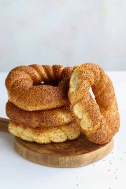 Beyaz arka planda susamlı simit. Türk kahvaltısı. dikey görünüm. Kapat.