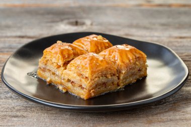 Ahşap zemin üzerinde ceviz baklava. Türk usulü ceviz baklavası sunumu ve servisi. Yatay görüş. Kapat.