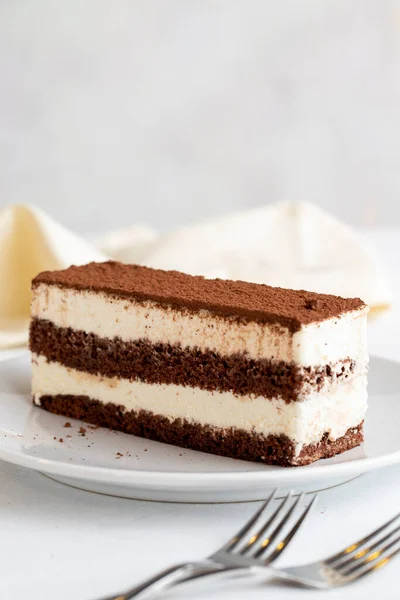 白を基調としたティラミスデザート イタリアの甘いデザートのコンセプト ティラミスケーキのプレート 閉めろ 選択的集中 垂直方向の眺め 物語形式 — ストック写真