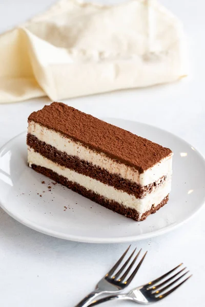 白を基調としたティラミスデザート イタリアの甘いデザートのコンセプト ティラミスケーキのプレート 閉めろ 選択的集中 垂直方向の眺め 物語形式 — ストック写真