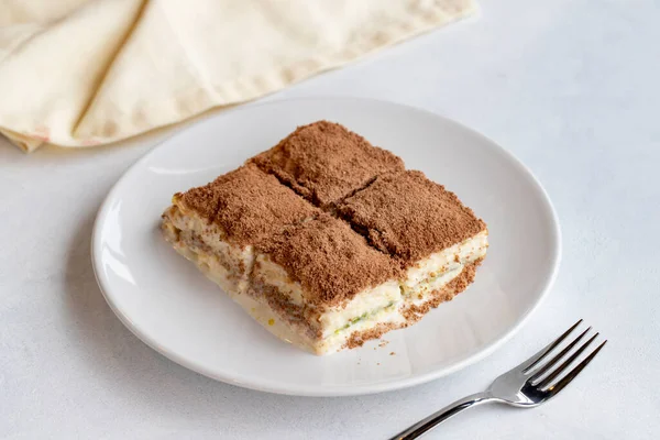Beyaz arka planda soğuk baklava. Türk tatlısı konsepti. Bir tabak dilimlenmiş orman meyveli kek. Bir tabak soğuk süt baklavası. Akdeniz pastanesi. Kapat. Seçici odaklanma. Yatay görüş. Yerel adı soguk baklava