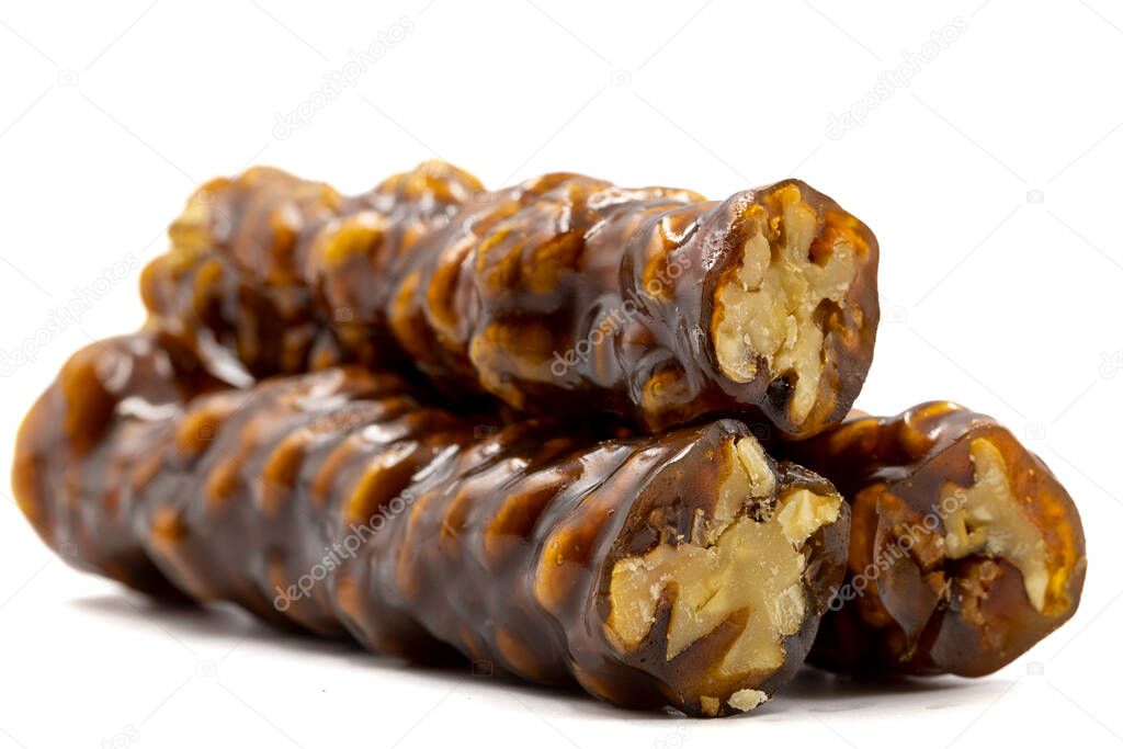 Sausage walnuts on a white background. Turkish walnut raisin sausage sweet. A sweet snack made by drying molasses and walnuts. local name ceviz sucuk