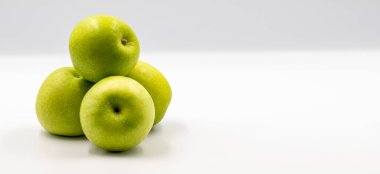 Beyaz arka planda ekşi elmalar. Olgun yeşil, ekşi elma tonuyla birleşmiş. Metin için boş alan. Boşluğu kopyala