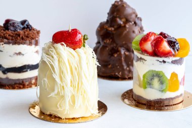 Beyaz arka planda çeşitli lezzetli pastalar.