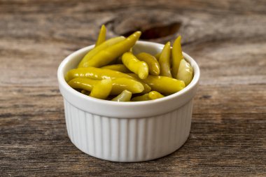 Ahşap arka planda yeşil biber turşusu