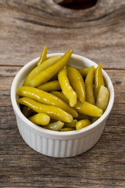 Ahşap arka planda yeşil biber turşusu