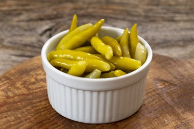 Ahşap arka planda yeşil biber turşusu