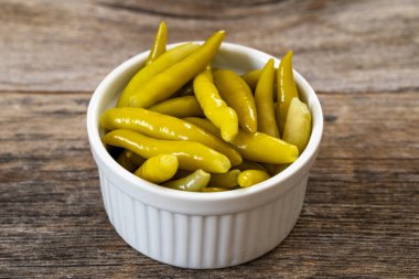 Ahşap arka planda yeşil biber turşusu