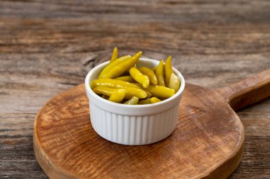 Ahşap arka planda yeşil biber turşusu