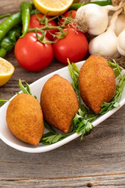 Ahşap bir arka planda Kibbeh. Doldurulmuş Köfte, Falafel, Icli Kofta, Quibe