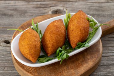 Ahşap bir arka planda Kibbeh. Doldurulmuş Köfte, Falafel, Icli Kofta, Quibe