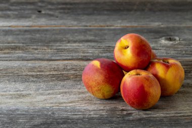 Ahşap arka planda canlı şeftaliler ve nektarinler. Boşluğu kopyala