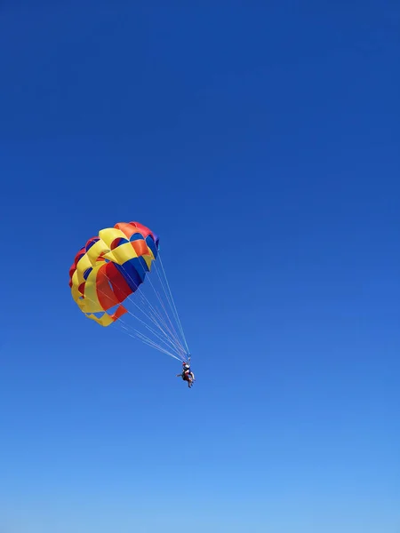 Pareja Joven Vuela Cielo Azul Usando Colorido Paracaídas —  Fotos de Stock